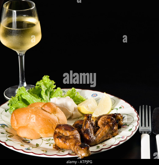 close-up-of-roasted-chicken-and-bun-in-a-plate-with-a-glass-of-wine-atpjpg.jpg