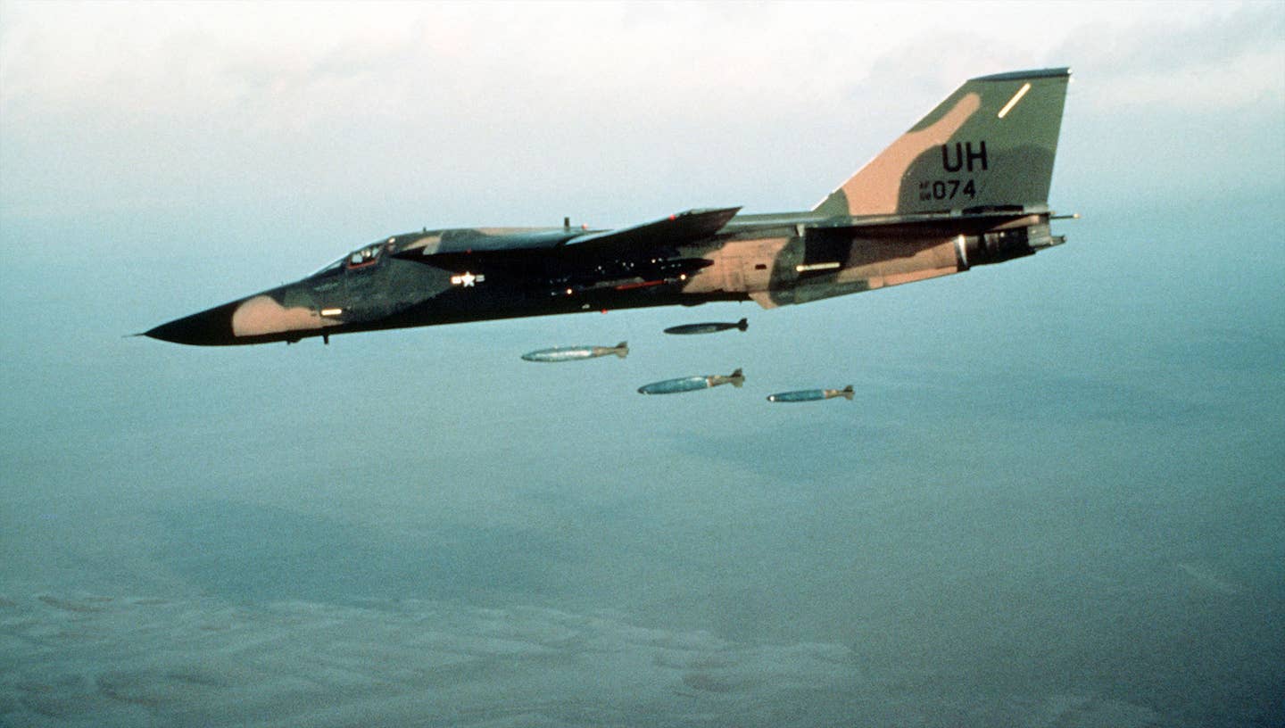 A U.K.-based 20th Tactical Fighter Wing F-111E drops inert bombs over a range. <em>U.S. Air For</em>ce