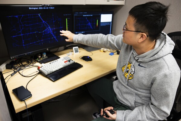 This undated photo provided by University of Michigan College of Engineering shows Dr. Xingmin Wang, postdoctoral research fellow at the University of Michigan-Ann Arbor, showing off a visualization of connected vehicle trajectory data insights which aid in the optimization of traffic signals. Smarter vehicles could mean some of the most dramatic changes for the traditional traffic signal since the yellow light was added more than a century ago. (Jeremy Little/University of Michigan College of Engineering via AP)