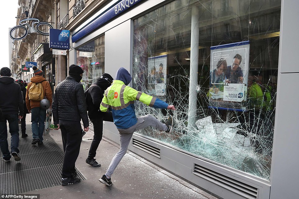 9595400-6685729-Men_destroy_the_window_of_a_bank_The_protest_in_the_French_capit-a-43_1549728435067.jpg