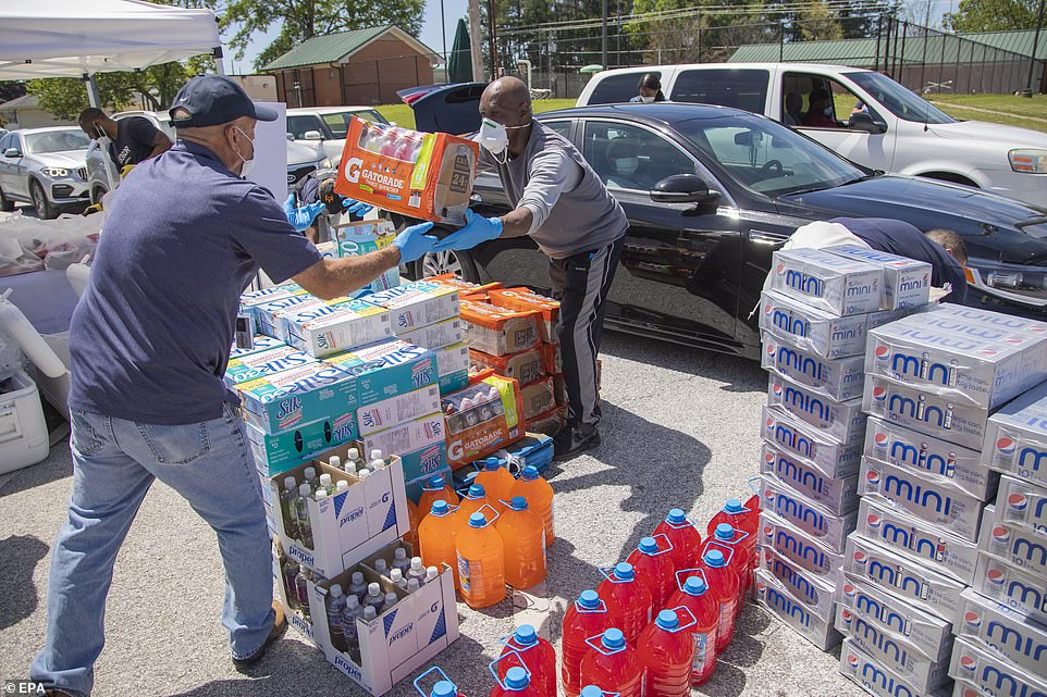 27369624-8233545-Volunteers_load_vehicles_with_food_during_a_pop_up_grocery_store-a-18_1587266459722.jpg