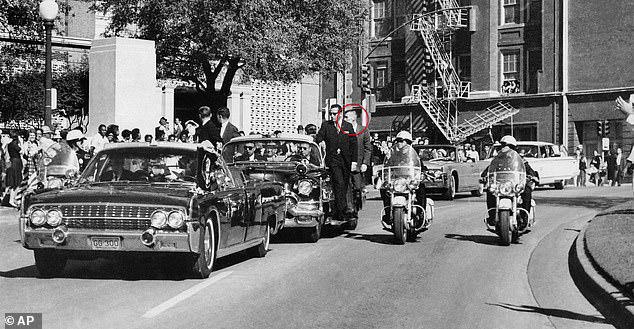 Landis (circled) is seen looking over his right shoulder after hearing a gunshot. In the limousine, Kennedy can be seen hunched over, clutching his neck, second before another bullet ripped through his head and killed him