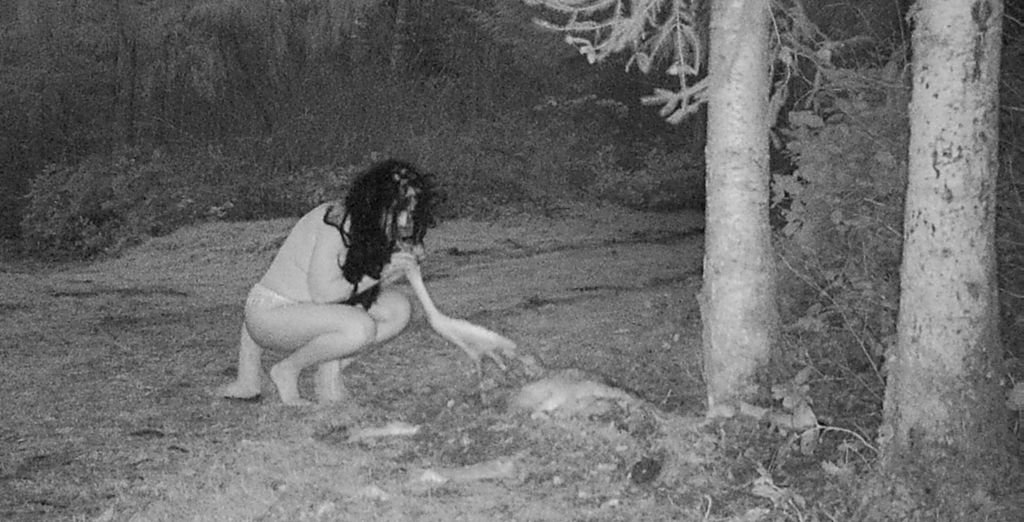 One of the witches reaches for the dead deer in the chilling footage.